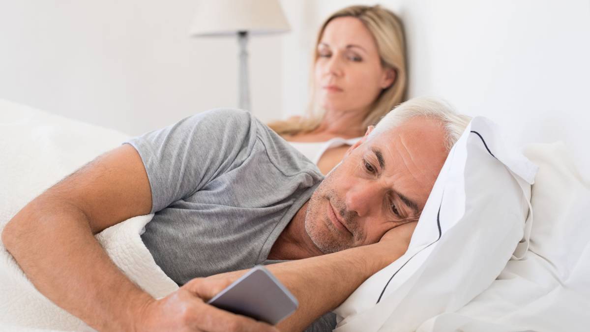 Man looking at his phone in bed