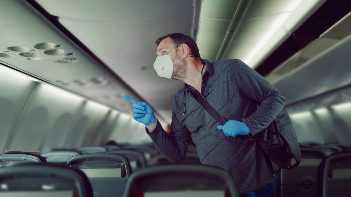 Man with a mask and gloves on a flight