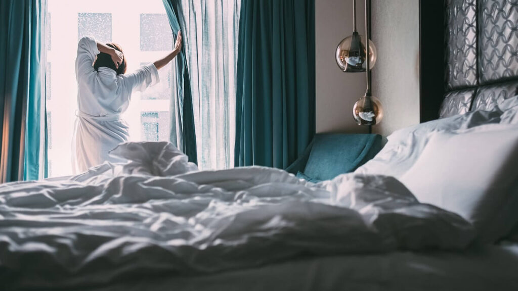 woman waking up in hotel room