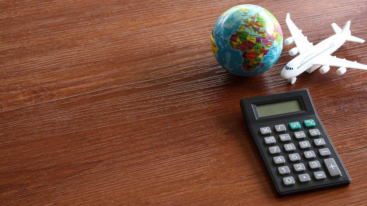 Calculator next to a globe and a small aeroplane