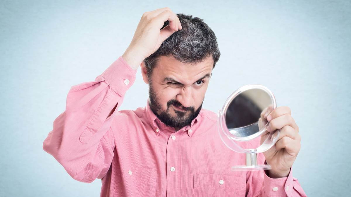Man looking at his hair in the mirror