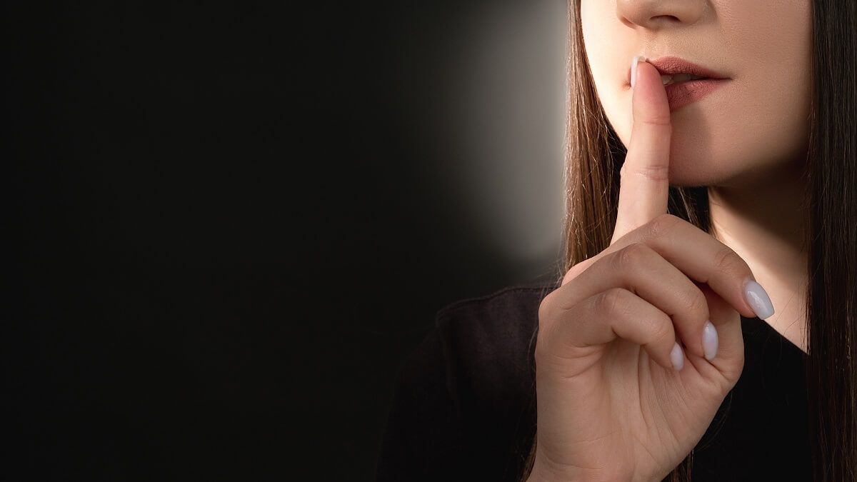 woman with finger pressed to lips