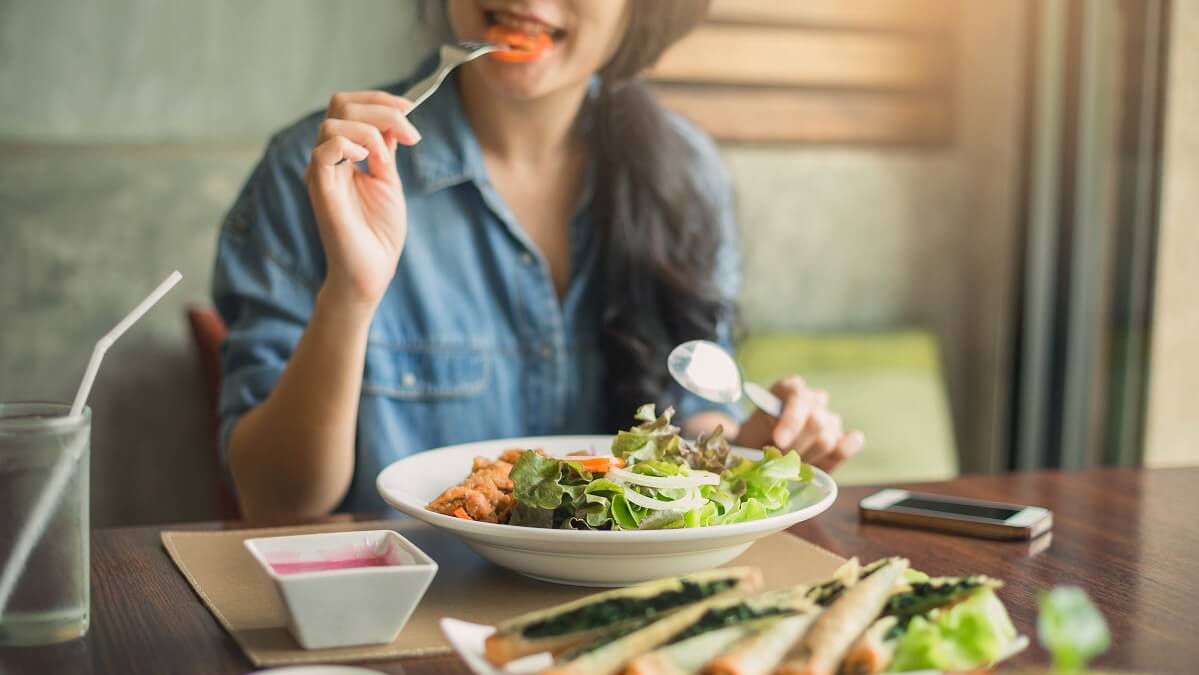 woman eating salad to lower cardiovascular risk