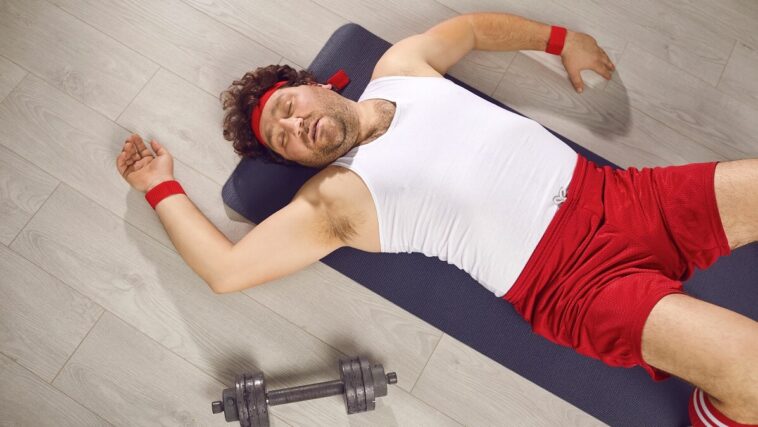 exhausted man on floor of gym