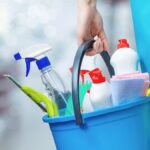 woman carrying bucket of cleaning products