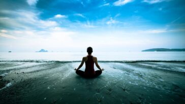 woman practicing mindfulness on beach