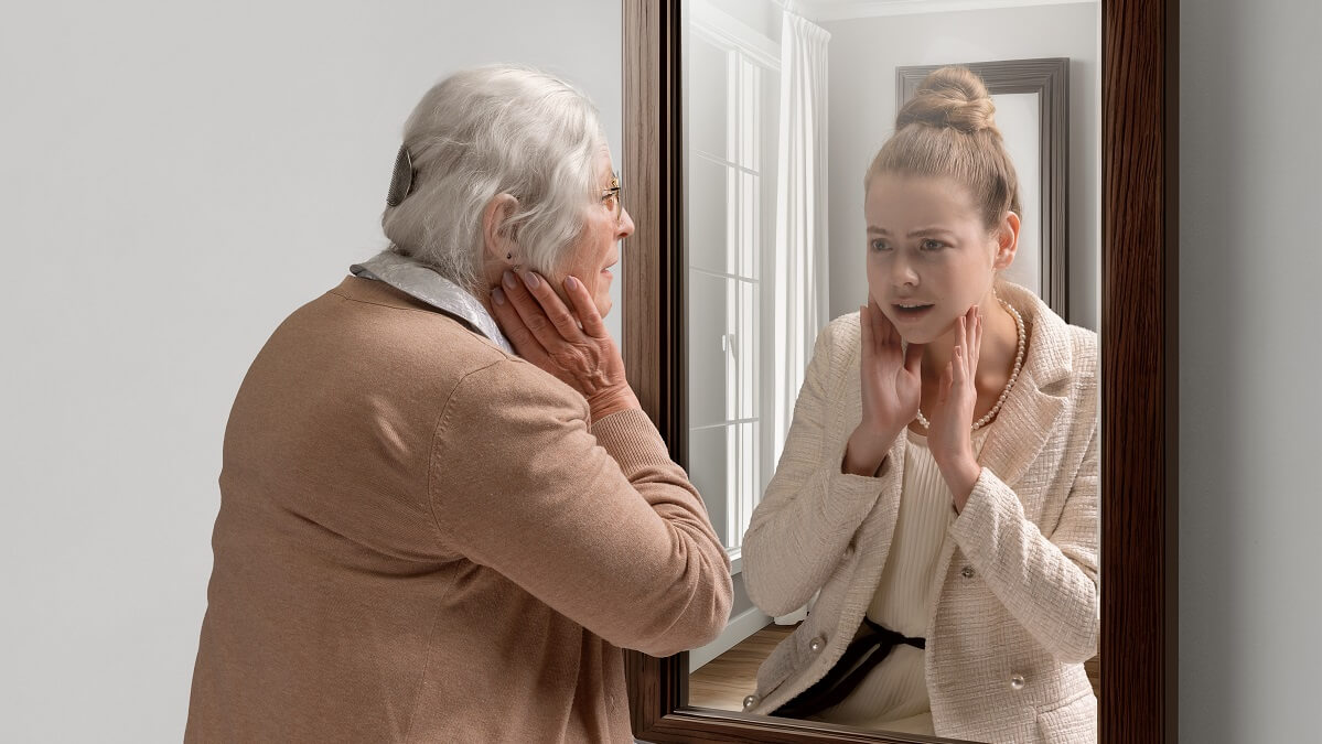 woman experiencing old age looking in mirror