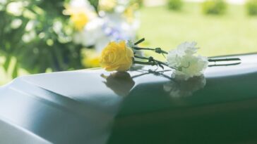roses on casket at funeral