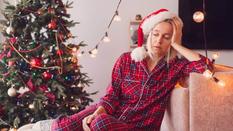 Woman looking a bit tired near a Christmas tree