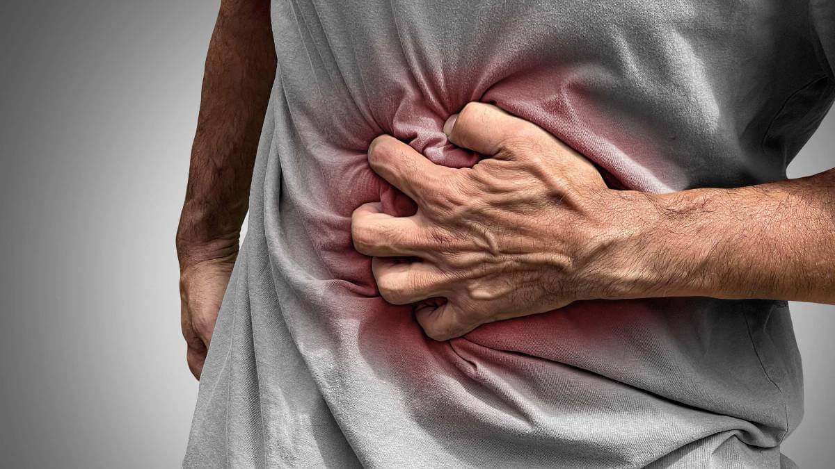 A man clutching his stomach with Crohn's