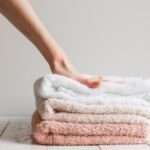 woman touching a stack of soft towels