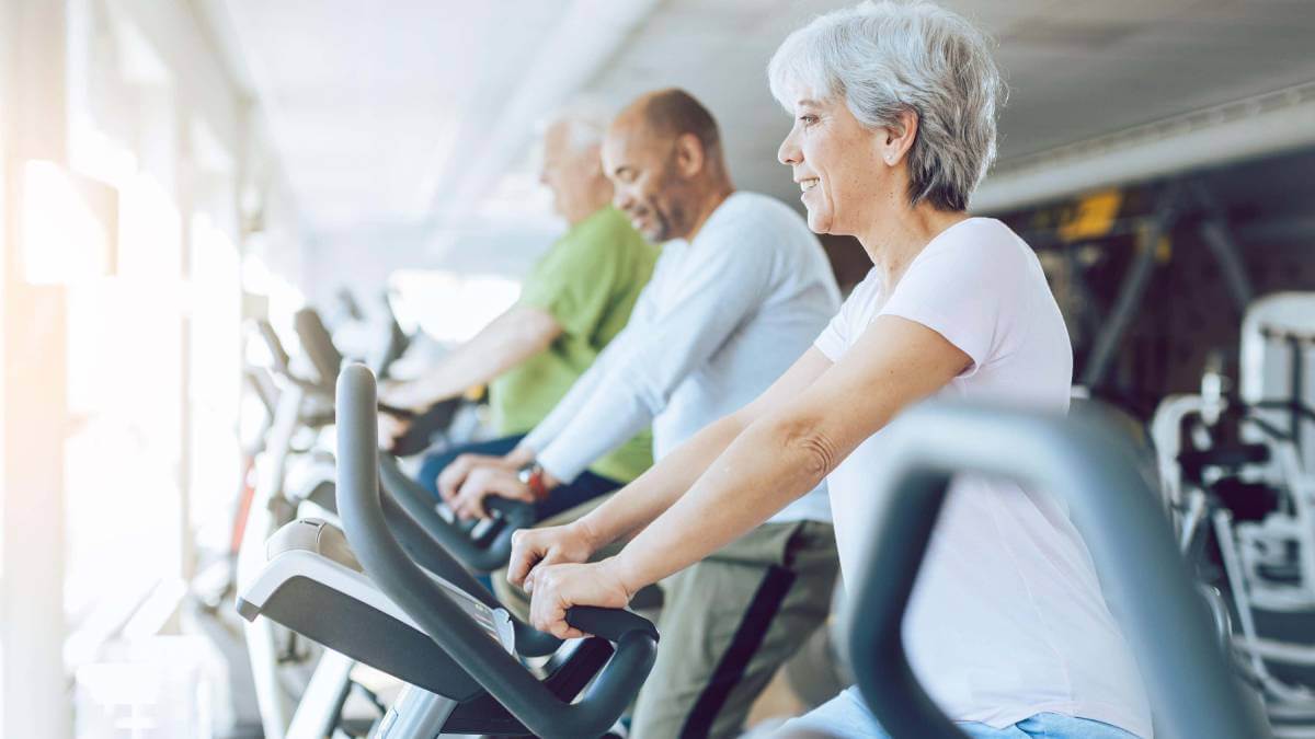 A group of older people on exercise bikes