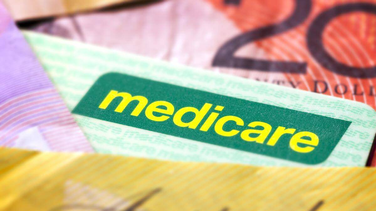 A Medicare card on a pile of money