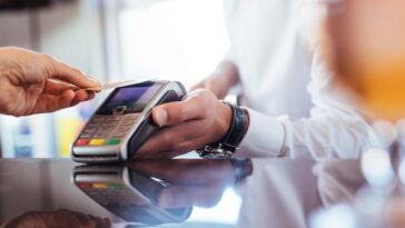 A person using a card to pay with a surcharge