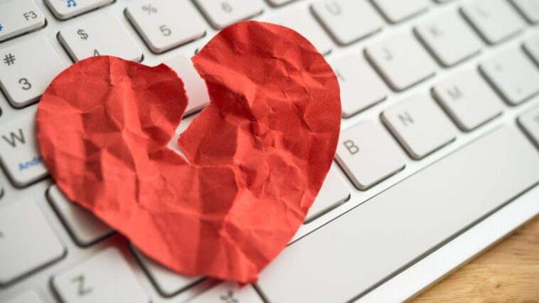 A broken paper heart on a keyboard