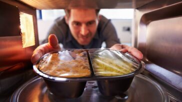Man heating a ready meal in a microwave