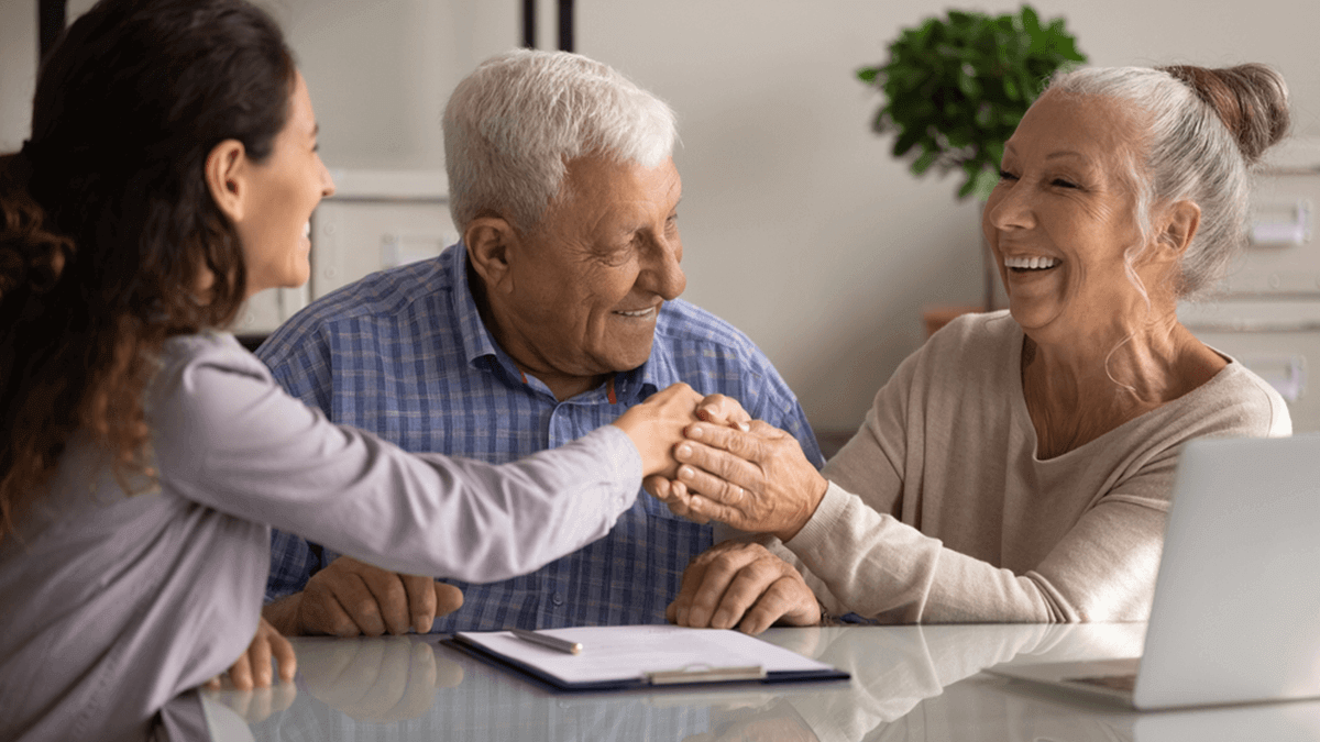 Senior couple meeting with agent shaking hands with realtor