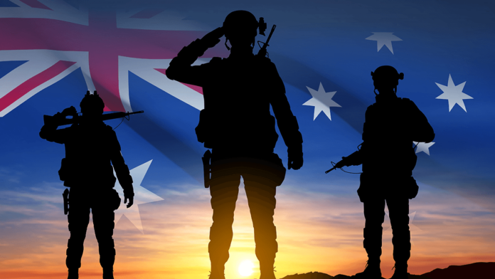 Silhouette of Soldiers with Australian flag on background of sunset