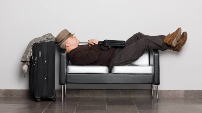 Man sleeping at an airport due to a flight delay