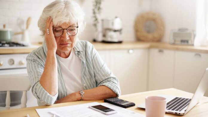 Older woman looking sad at her finances