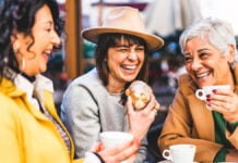 Group of senior women at bar cafeteria enjoying breakfast drinking coffee