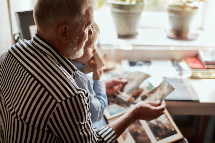 Man shows his grandchild photos
