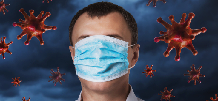 A man with a medical mask covering his face against the sky with a coronavirus
