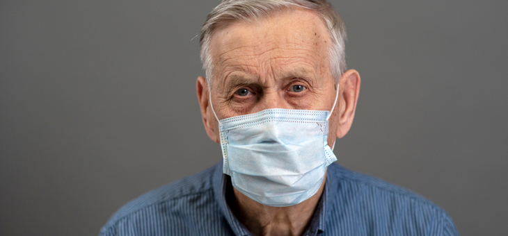 Portrait of an old man, 80 years old, in a medical mask.