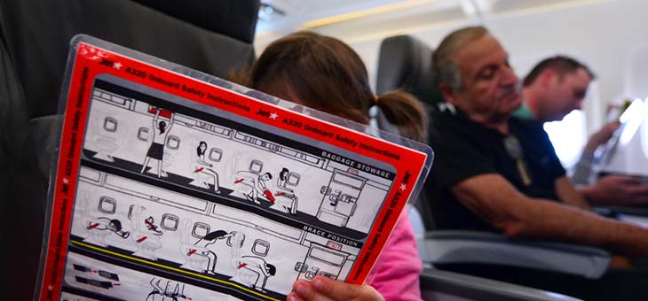 kid reading plane evacuation instructions