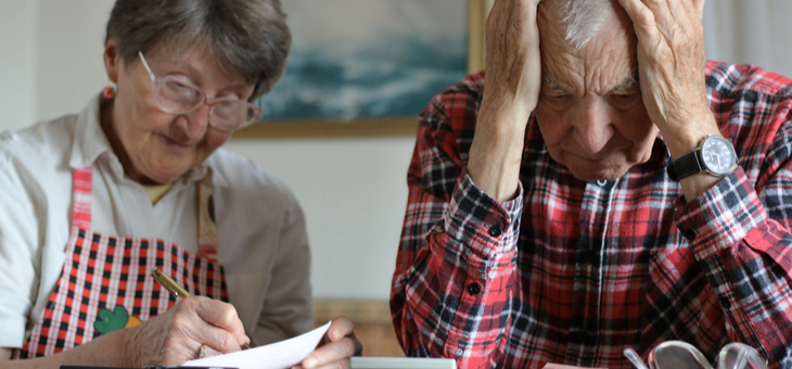 Desperate senior couple counting money from retirement