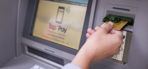 A person inserts their card into an ATM machine