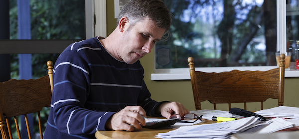 Stressed man looks at his age pension paperwork