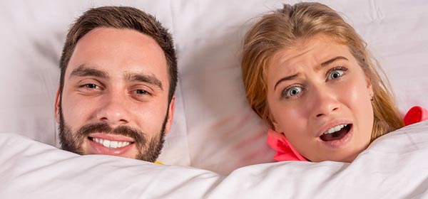 Couple with the covers drawn up against farts
