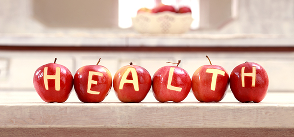 Detox apples lined up on bench spelling health