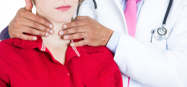 Doctor checking a womans thyroid