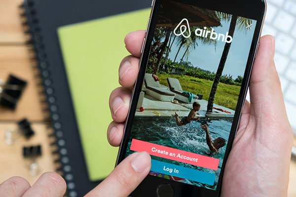 hand holding phone with airbnb on screen