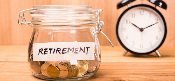 Jar of retirement savings coins beside an alarm clock
