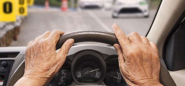 Older hands on steering wheel