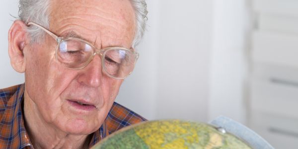 age pensioner looking at the globe planning travel
