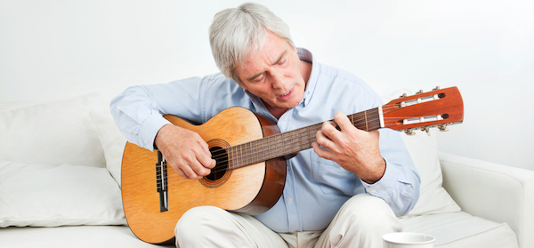 Senior man learning the guitar a hobby that can make you smarter