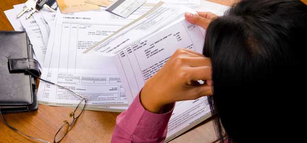 Woman looking at unpaid bills wondering what to do when you cant pay a bill