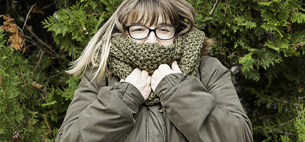 woman with warm winter jacket up around her face