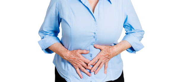 Woman holds her stomach as she suffers from irritable bowel syndrome