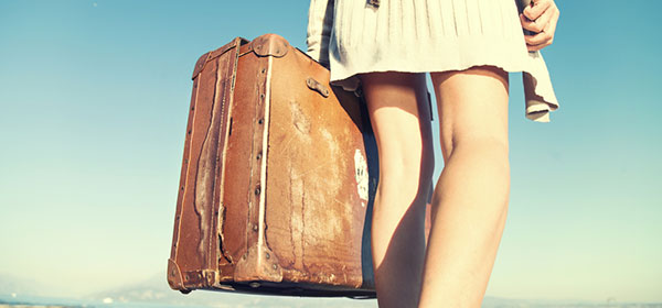 young woman holds a vintage suitcase